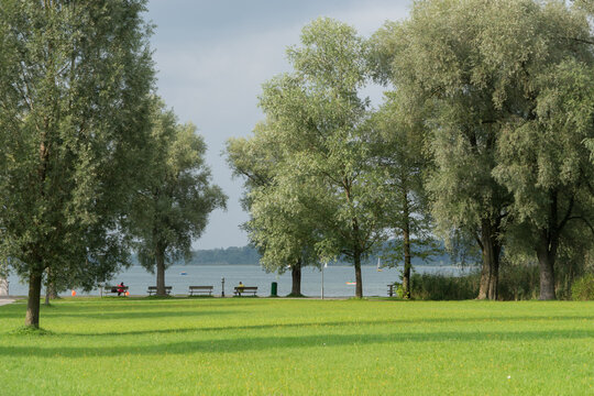 Benches at the water, in a green park landscape at the Chiemsee in Bernau, Germany
