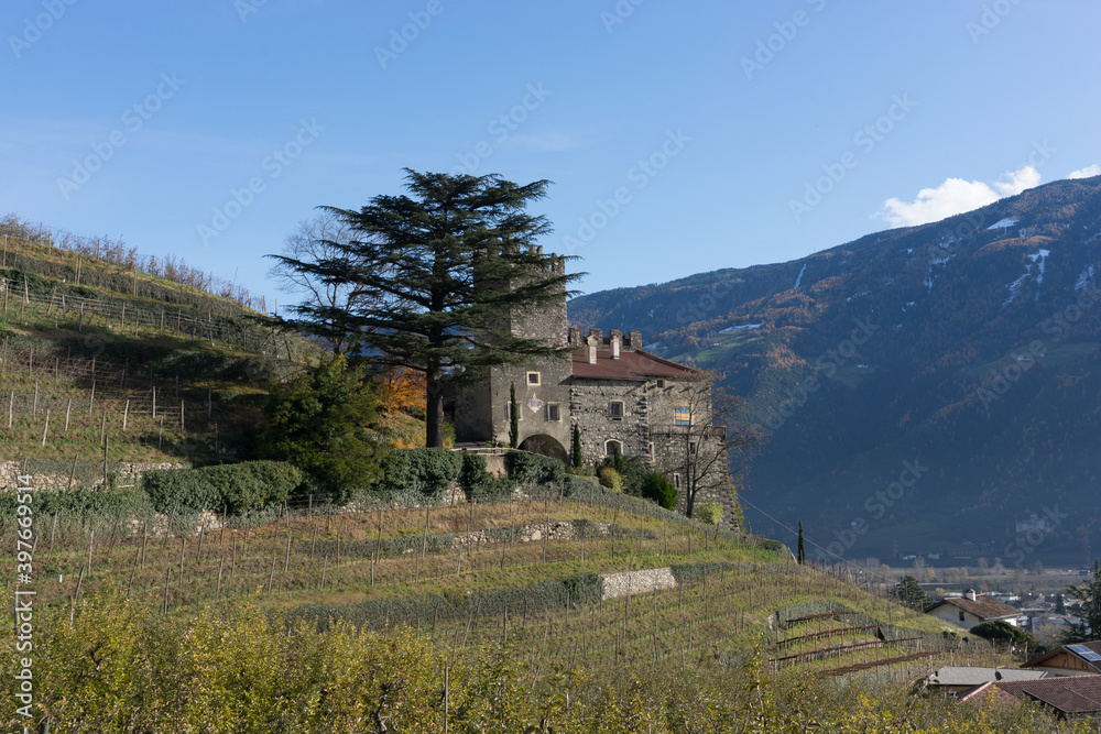 Wall mural picturesque mountain landscape in naturns in south tyrol in autumn, view from the hill to an old cas