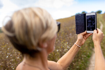 woman in field taking picture