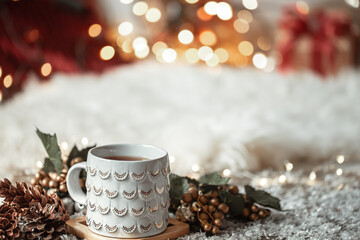 Obraz na płótnie Canvas Cozy winter background with a beautiful cup on a blurred background with bokeh.