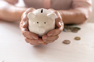 Hands of old women's hold a piggy Bank, the concept of retirement.
