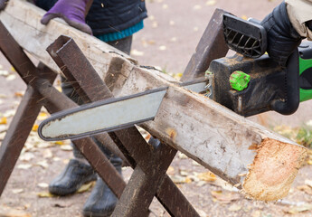 A man cuts boards with an electric saw. Hard work. Construction.