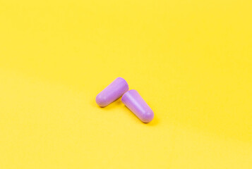 Pink earplugs on a yellow background. Top view . Place for an inscription. Advertising