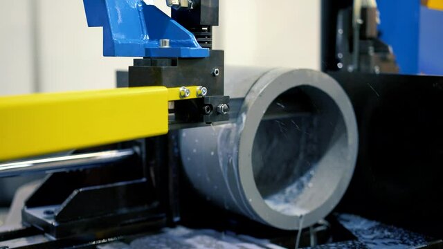 A modern metalworking machine cuts a metal pipe. band saw cutting tool steel bar by automatic feed, high performance cutting machine, cutting steel bar, high speed cutting, band saw for industrial use