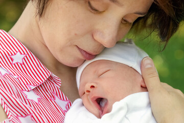 young woman holds newborn baby in her arms