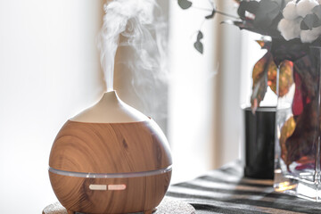Modern oil aroma diffuser in the living room on the table.
