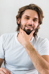 Man hydrating skin. Young fine-looking man skincare beauty portrait isolated in studio.