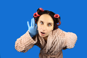 young housewife in curlers and dressing gown listens, eavesdropping