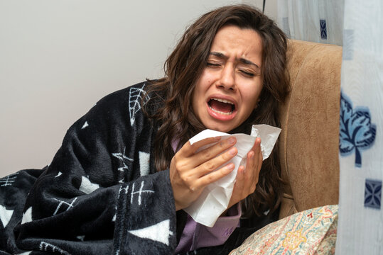 Young Woman Sneezing Suffering From Virus Infection. Home Quarantine Due To Covid Disease.