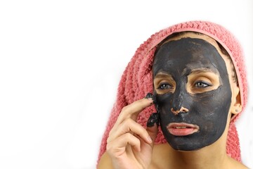 beautiful girl puts a cosmetic mask on her face. Spa procedures. Isolated on white