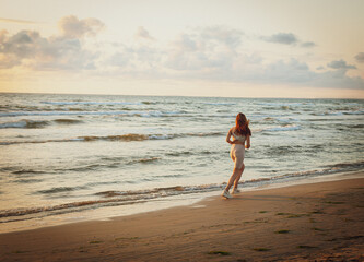 girl jogging along sandy beach