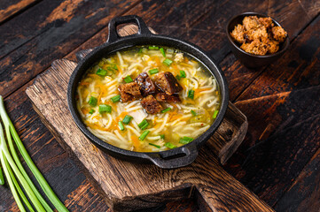 Chicken soup with noodles and vegetables. Dark wooden background. Top view