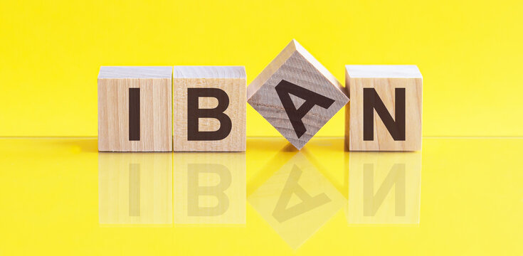 iban word is made of wooden building blocks lying on the yellow table, concept