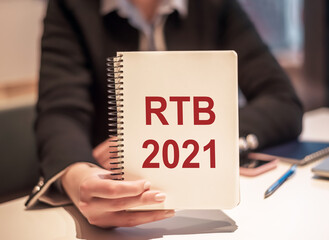 Business woman holds a notebook with the text RTB 2021 - (Real-time bidding acronym).