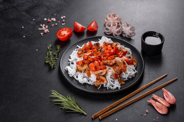 Tasty rice noodles with tomato, red pepper, mushrooms and seafood