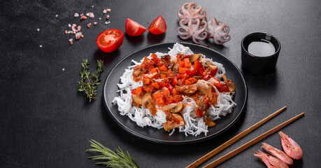 Tasty rice noodles with tomato, red pepper, mushrooms and seafood
