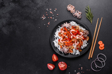 Tasty rice noodles with tomato, red pepper, mushrooms and seafood