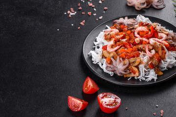 Tasty rice noodles with tomato, red pepper, mushrooms and seafood