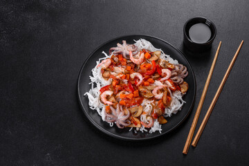 Tasty rice noodles with tomato, red pepper, mushrooms and seafood