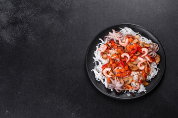 Tasty rice noodles with tomato, red pepper, mushrooms and seafood