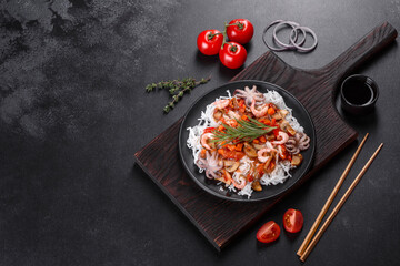 Tasty rice noodles with tomato, red pepper, mushrooms and seafood