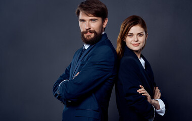 successful people in suits stand with their backs to each other on gray background business finance