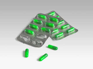 Green gelatin capsules in shiny blister packs
