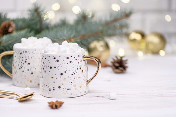 White cup of cappuccino or cocoa with christmas tree on the buckground of gold bokeh, New Year drink