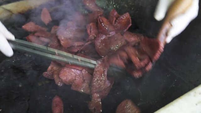 A chef is frying Turkish dried sausage.