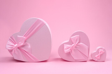 Tree Pink heart-shaped gift box with bow for Valentine's Day on a pink background, minimalism