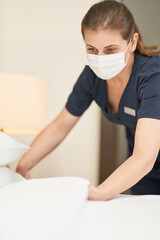 Experienced young maid cleaning a luxury hotel room