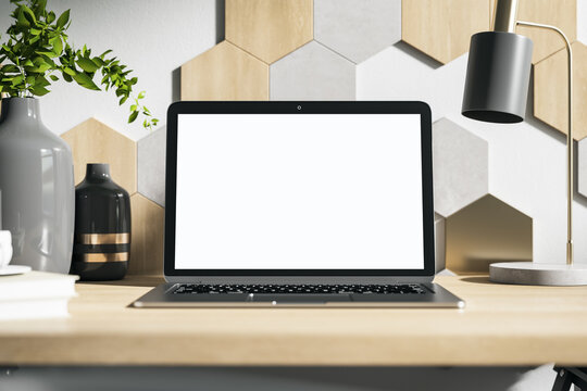 White laptop screen on wooden designer desktop
