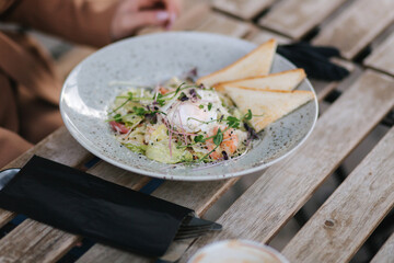 Close up of fresh vegan salad with shrimps outdoor in cafe on terrace