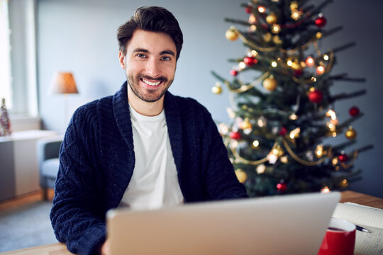 Man looking at camera while working remotely during Christmas