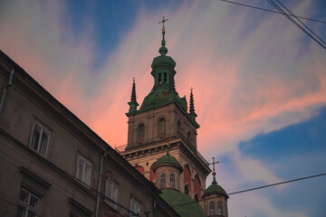 Fototapeta na wymiar architecture building landmark touristic photography of tower in Lviv Ukraine Eastern Europe city foreshortening from below in evening sunset time with purple and blue sky background scenic view