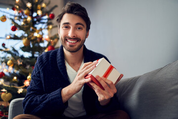 Man showing present during christmas video call practicing social distancing
