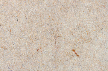 Old paper texture, cardboard background close-up. Recyclable material with villi, fluff and other inclusions