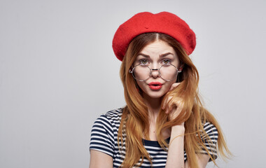 Fashionable woman in beret and striped t-shirt on gray background cropped view