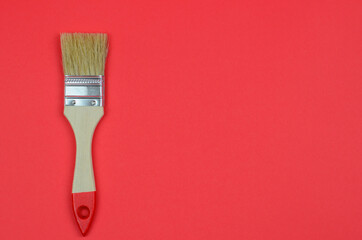 Brush for painting on a red background close up