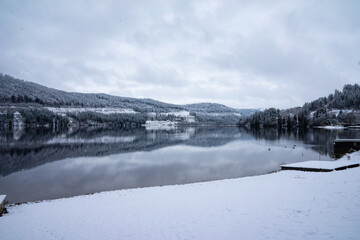 Schwarzwald See im Winter mit Schnee und Wolken