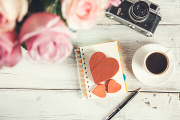 roses with heart on notepad and cup of coffee