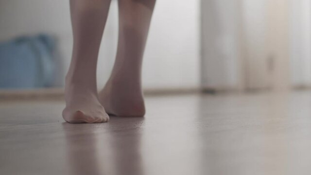 Feet of a girl dancer close-up at the warm-up before the performance, she kneads the muscles and joints