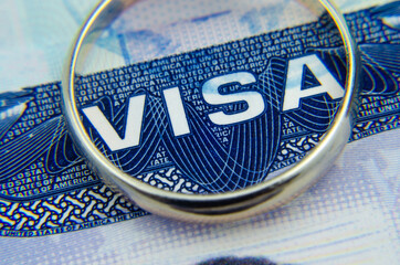 Macro photo of US entry visa sticker in a passport and a ring. Conceptual photo for fiancee visa...