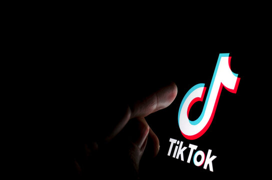 Stone / UK - July 28 2019: TikTok app logo on the screen and a finger about to touch it.