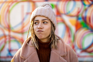 Playful young woman with braided hair outdoors
