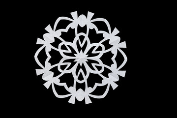 White openwork paper snowflake isolated on black. Christmas composition. Handmade new year decoration