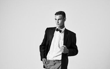 black and white photograph of a man in a jacket shirt and a bow tie around his neck