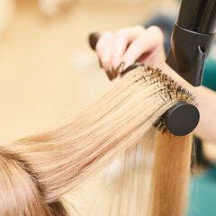 Repair long hair procedure. Haircut at salon. Woman hairstyle. Master hand with brush and fan....