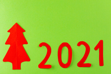 New Year's concept 2021. Christmas tree 2021 on a green background. Red New Year tree made of paper. Top view