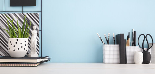 Desk at home office with supplies and blue wall Business workspace.	
